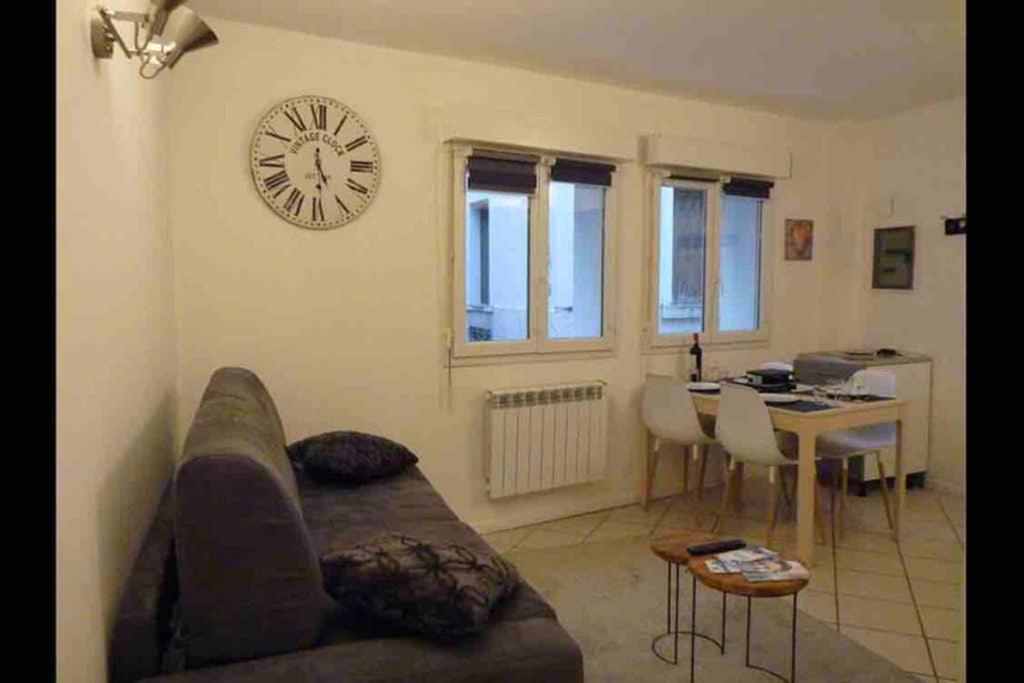 un salon avec un canapé et une horloge au mur dans l'établissement Centre Cauterets grand T2 entièrement rénové, à Cauterets