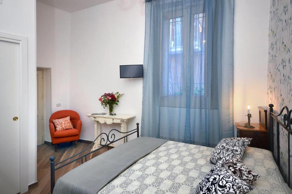 a bedroom with a bed and a chair and a window at B&B Il Lentisco in Camerota