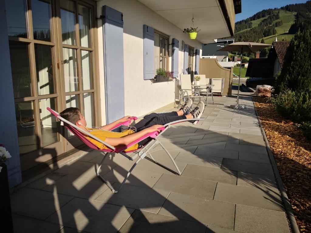 a man laying in a lawn chair on a patio at Jungholz Erlebnis in Jungholz