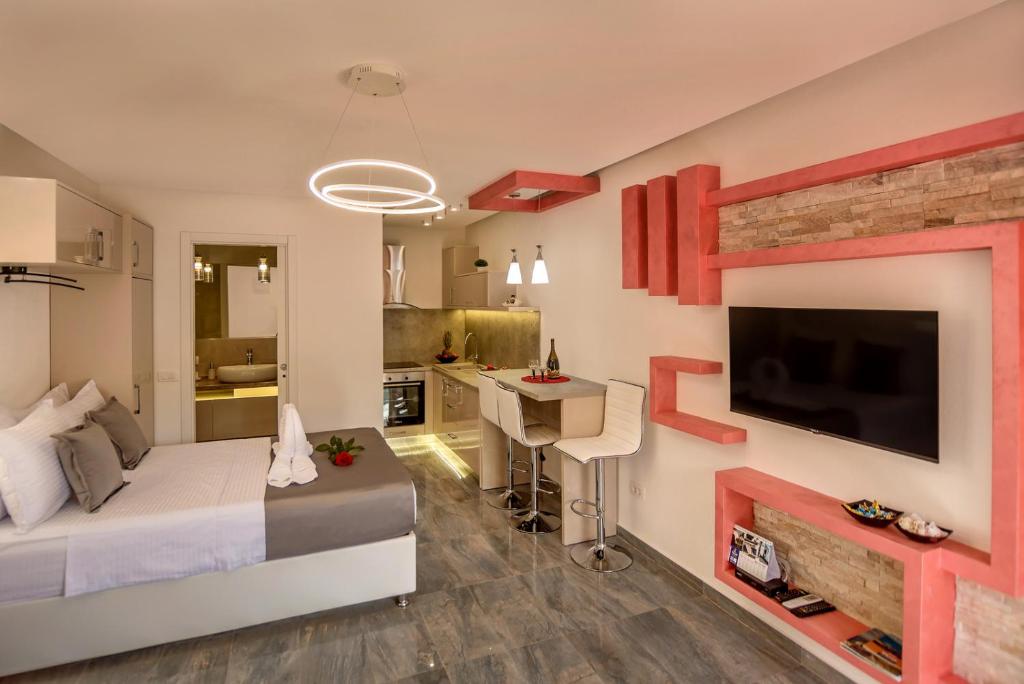 a bedroom with a bed and a desk and a tv at Apartments Vujicic in Tivat