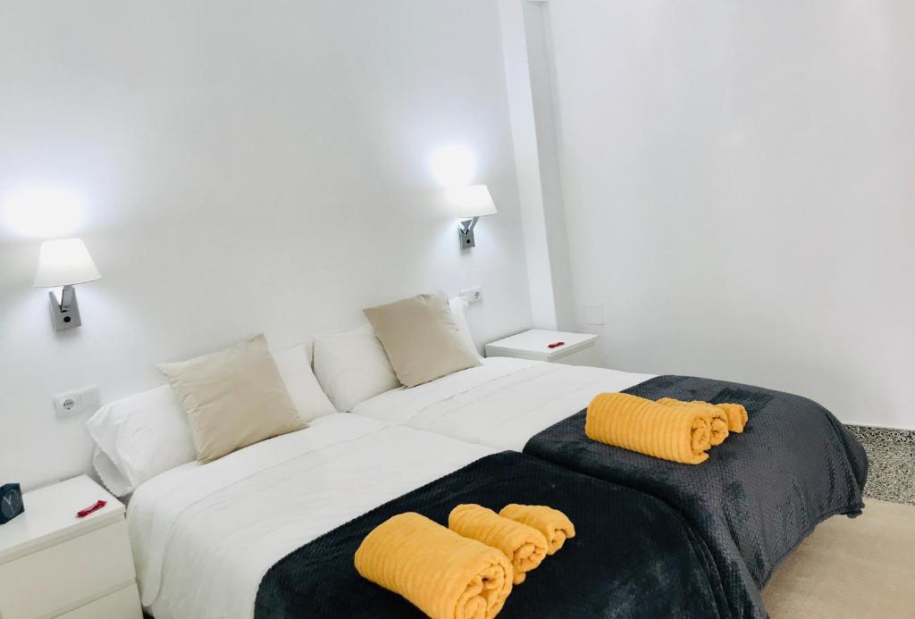 1 dormitorio con 1 cama grande y 2 almohadas amarillas en Apartamento Padrón Centro, Camino De Santiago P1 UR, en Padrón