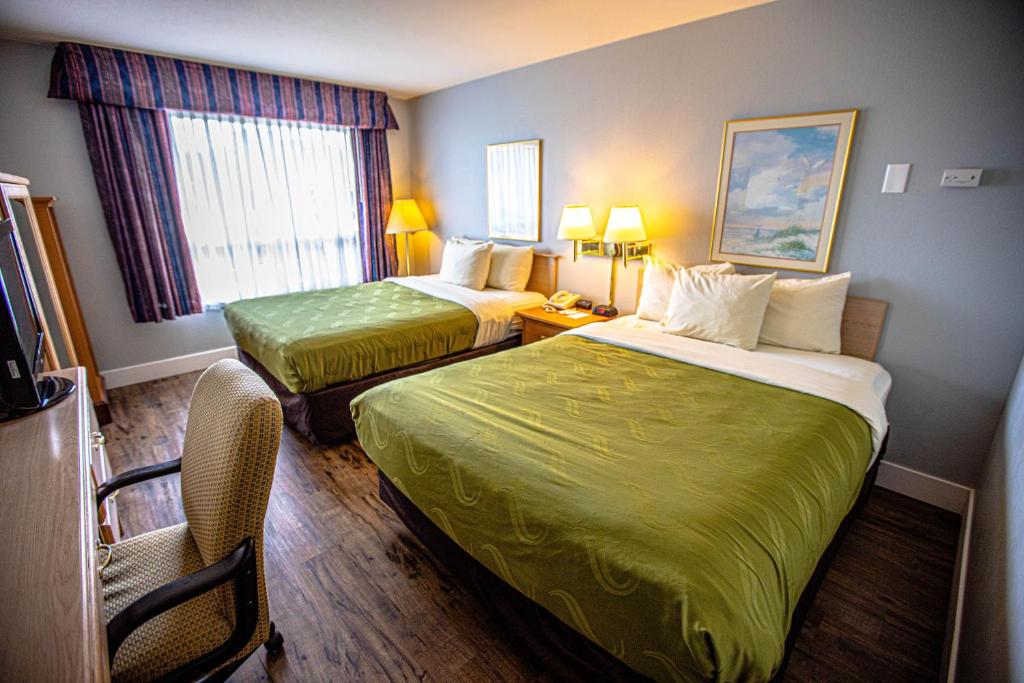 a hotel room with two beds and two lamps at Ocean Paradise Hotel & Resort in Ocean Shores