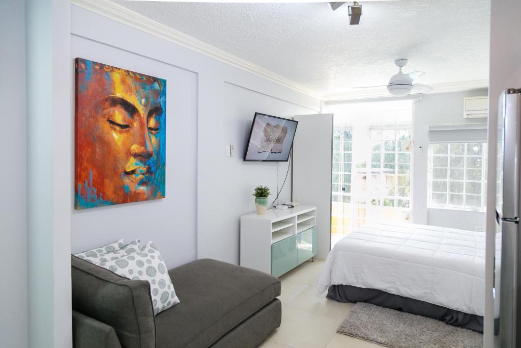 a bedroom with a bed and a painting on the wall at Choose To Be Happy at Seymour # 9 and #16 - Studio Apartments in Kingston