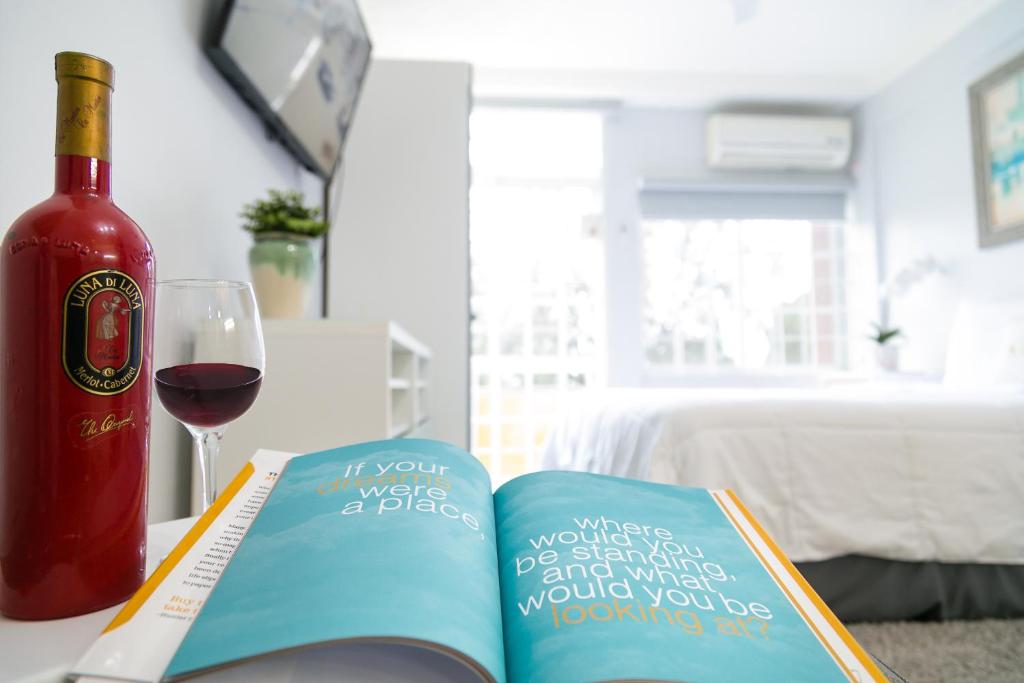 a bottle of wine and a book and a glass of wine at Choose To Be Happy at Seymour # 9 and #16 - Studio Apartments in Kingston