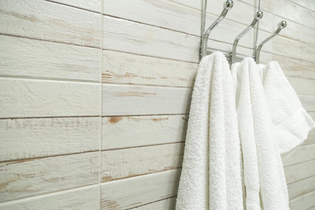 a group of white towels hanging on a rack in a bathroom at Choose To Be Happy at Seymour # 9 and #16 - Studio Apartments in Kingston