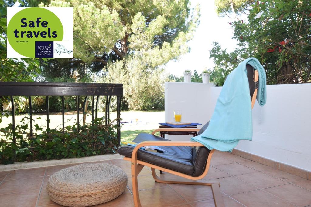 einen Stuhl mit einer Decke darauf auf einer Terrasse in der Unterkunft Casa Flor in Vilamoura