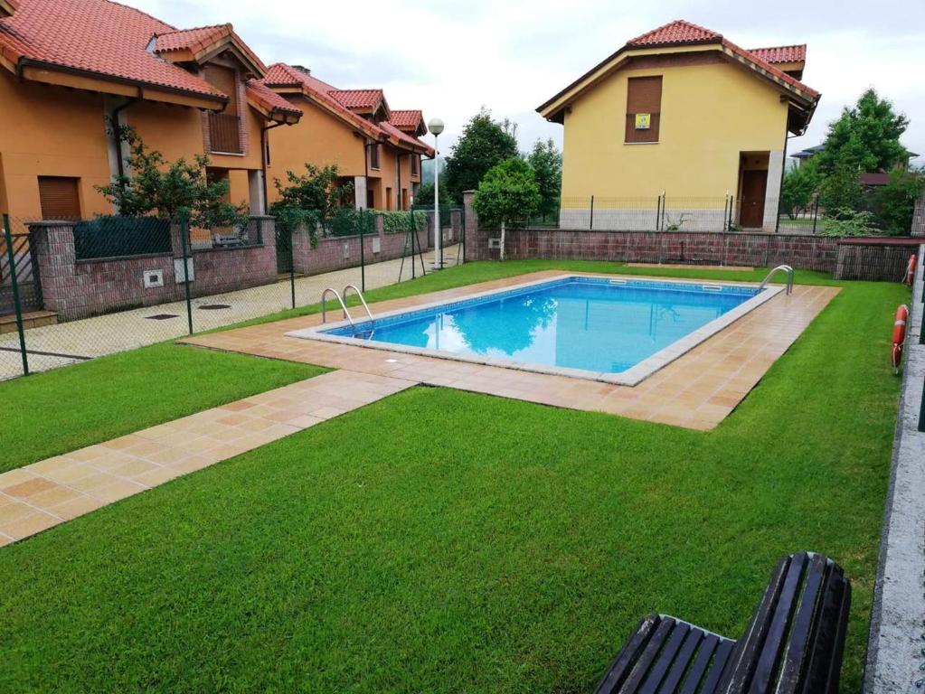 una piscina en un patio junto a una casa en 2 bedrooms house with shared pool enclosed garden and wifi at Suances 5 km away from the beach en Suances