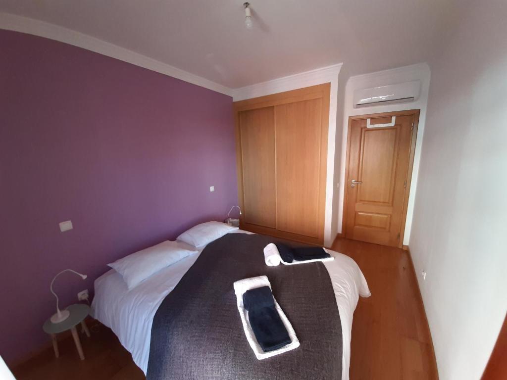 a bedroom with a bed with a cell phone on it at Faro Island Beach & Airport Apartment in Faro