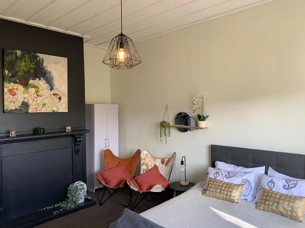 a bedroom with a bed and two chairs at Moore St Cottage in Ohakune