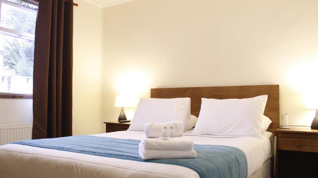 a bedroom with a bed with towels on it at Haiken Hostal in Punta Arenas