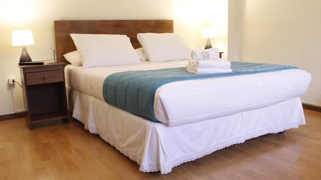 a bedroom with a large bed with two pillows at Haiken Hostal in Punta Arenas