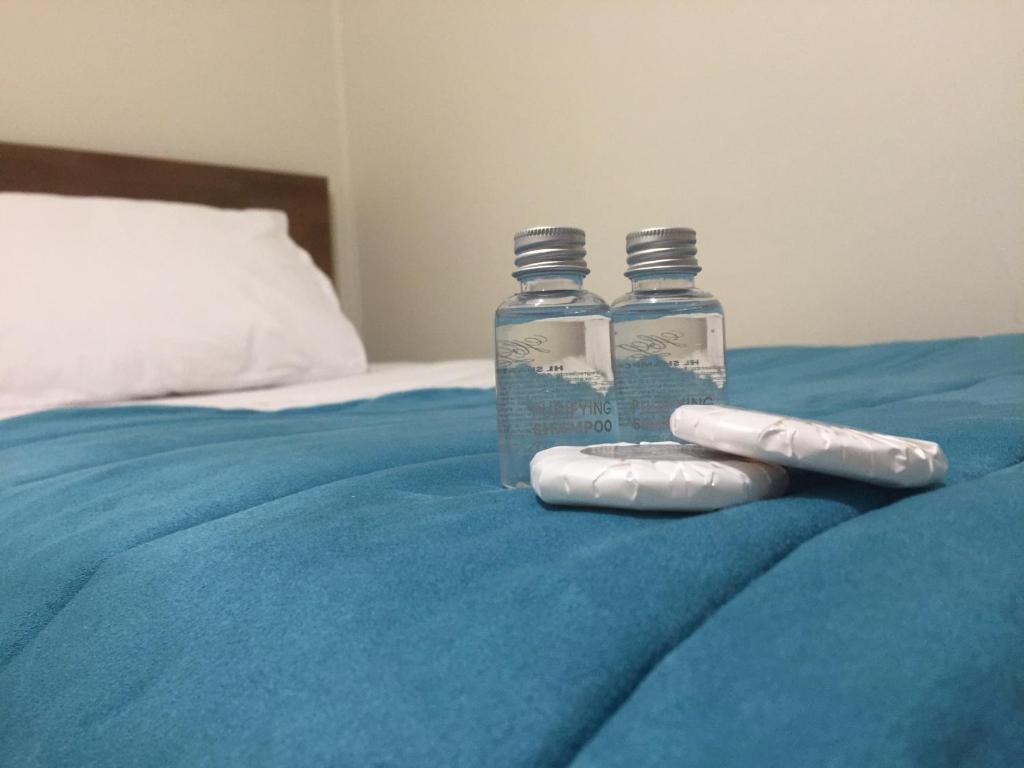 two syringes are sitting on top of a bed at Haiken Hostal in Punta Arenas