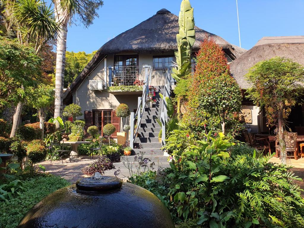 a thatched house with a staircase leading up to it at Waterhouse Guest Lodge in Waterkloof in Pretoria