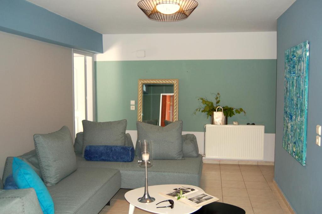 a living room with a couch and a mirror at Alkyoni Apartments & Studios in Poros