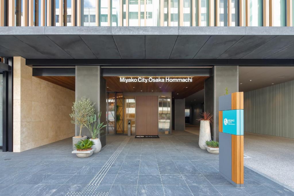 an entrance to a building with a sign on it at Miyako City Osaka Hommachi in Osaka