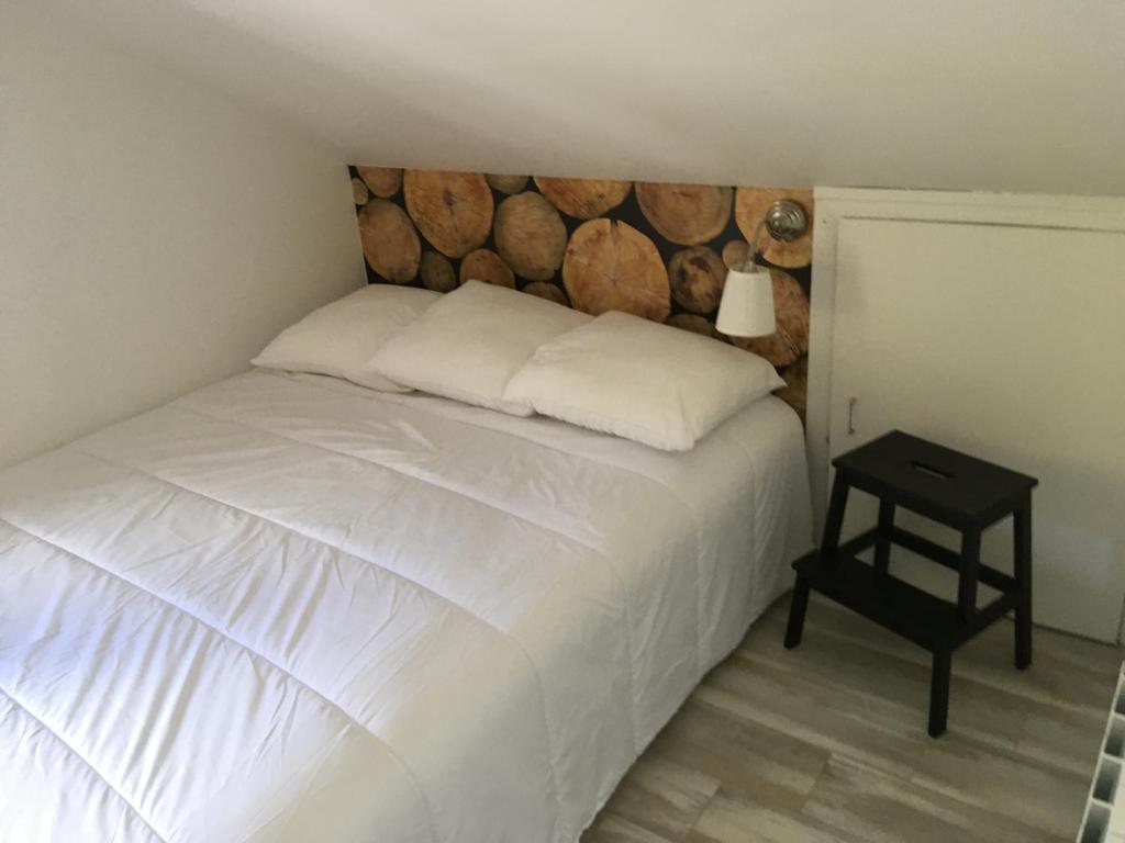 Schlafzimmer mit einem weißen Bett mit einem Kopfteil aus Holz in der Unterkunft Le petit Beillard in Gérardmer