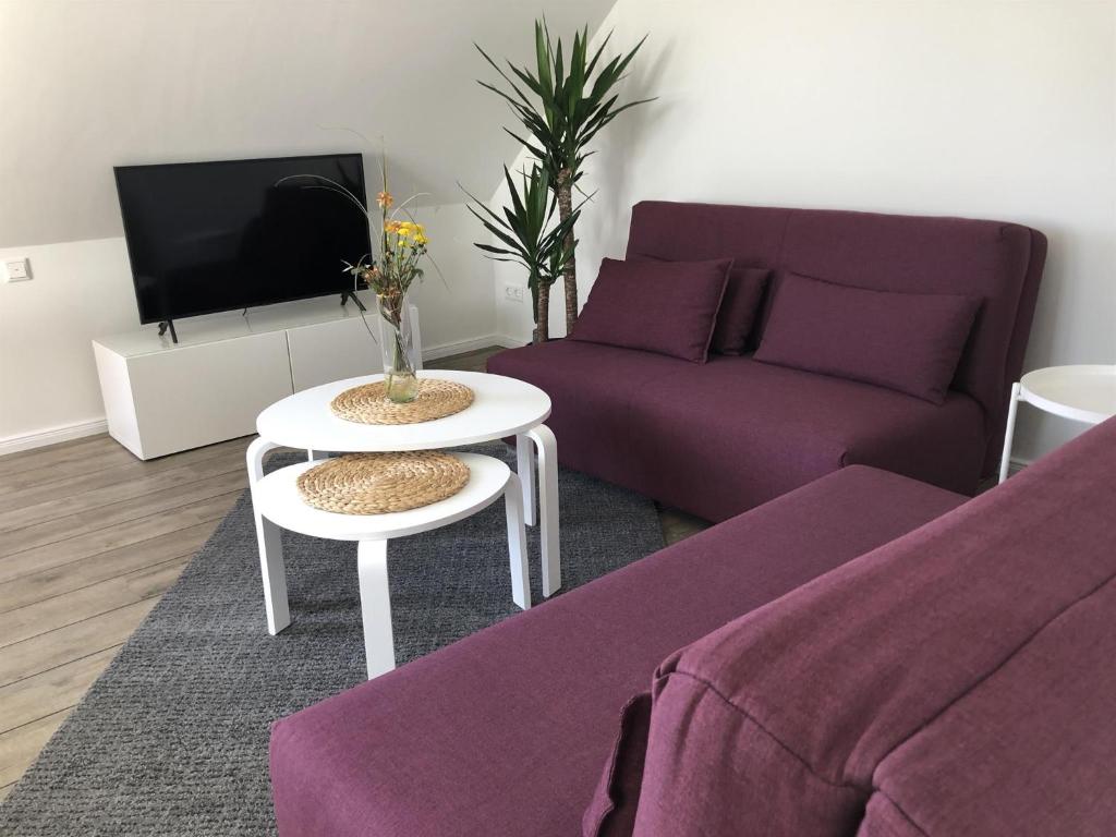 een woonkamer met een paarse bank en een tafel bij Ferienwohnung Böverdün in Sankt Peter-Ording