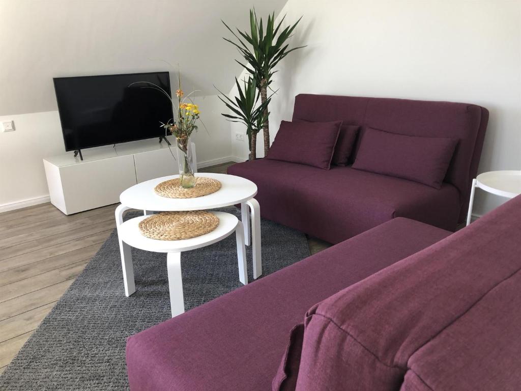 a living room with a purple couch and a table at Ferienwohnung Böverdün in Sankt Peter-Ording