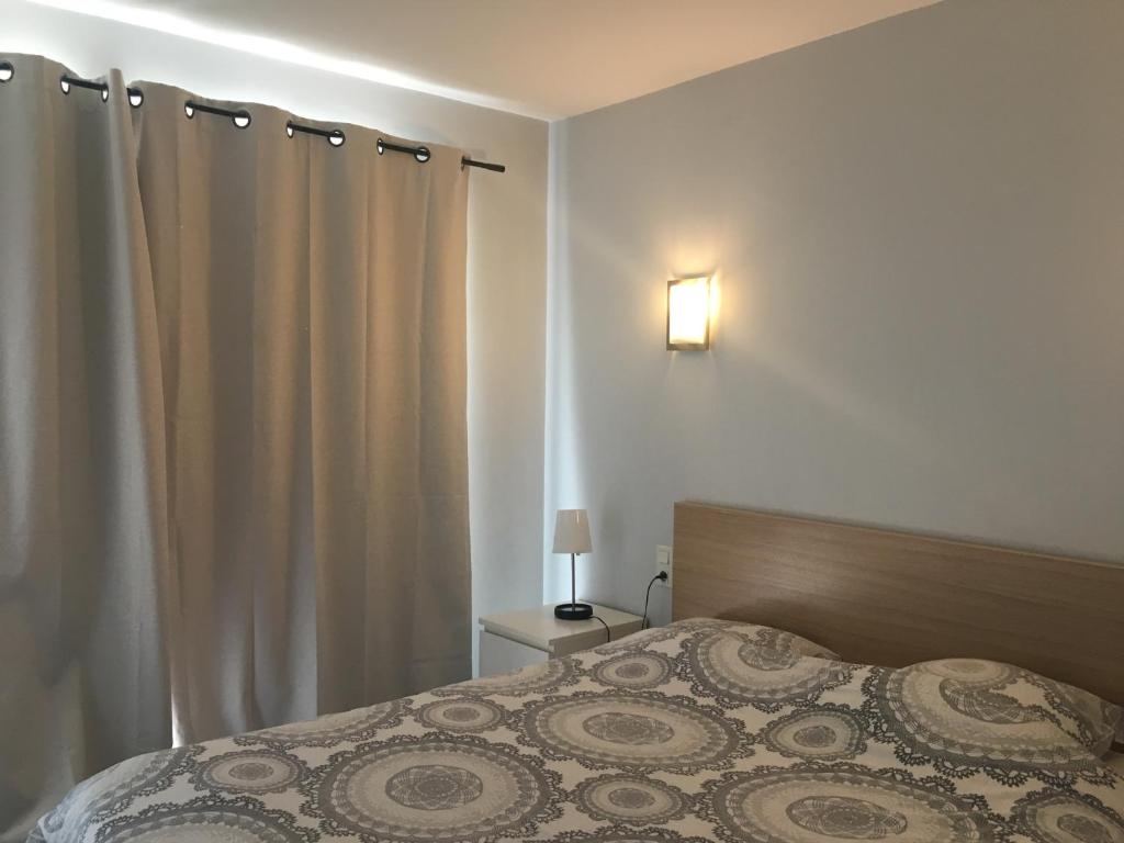 a bedroom with a bed and a curtain at RESIDENCE DU PORT in Le Bourget-du-Lac