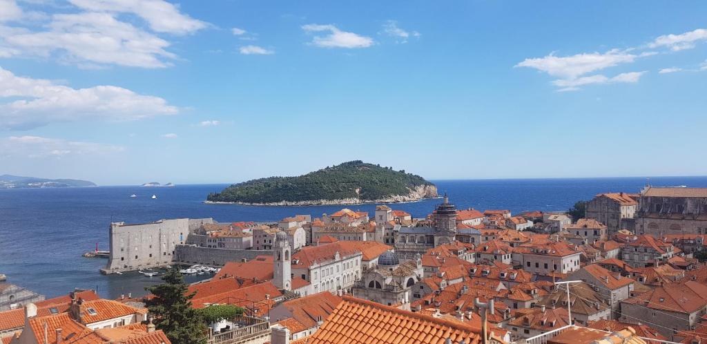 Blick auf eine Stadt mit roten Dächern und das Meer in der Unterkunft Guest House Katić in Dubrovnik