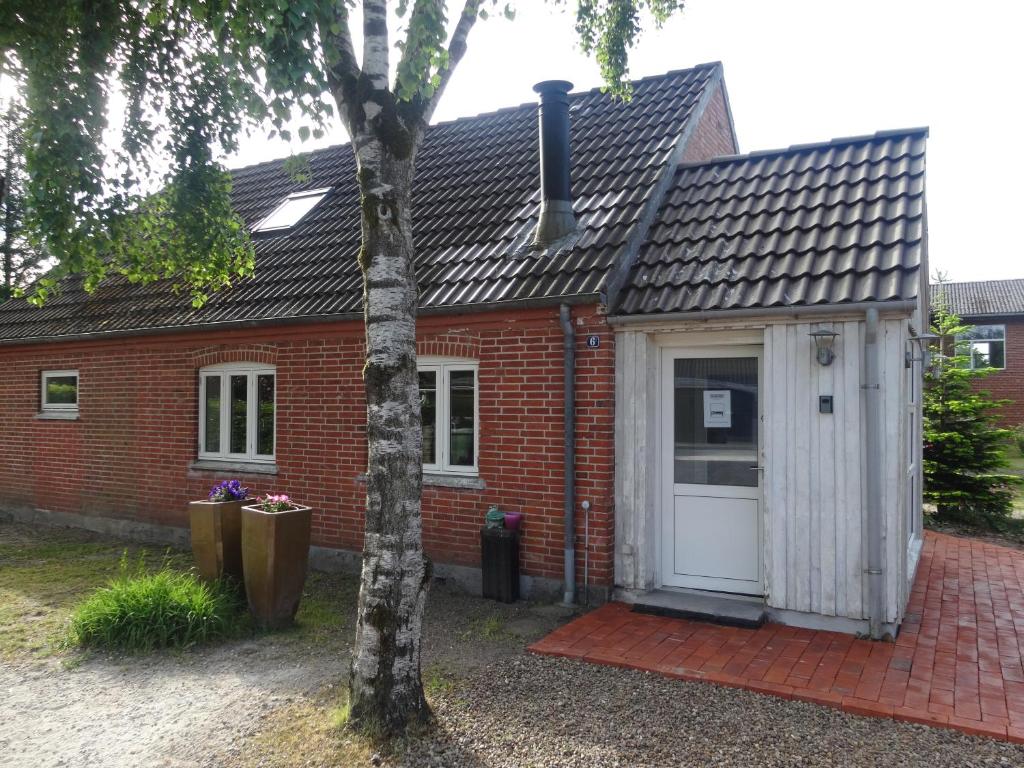 una casa de ladrillo rojo con puerta blanca en Elmealle 6, en Skjern
