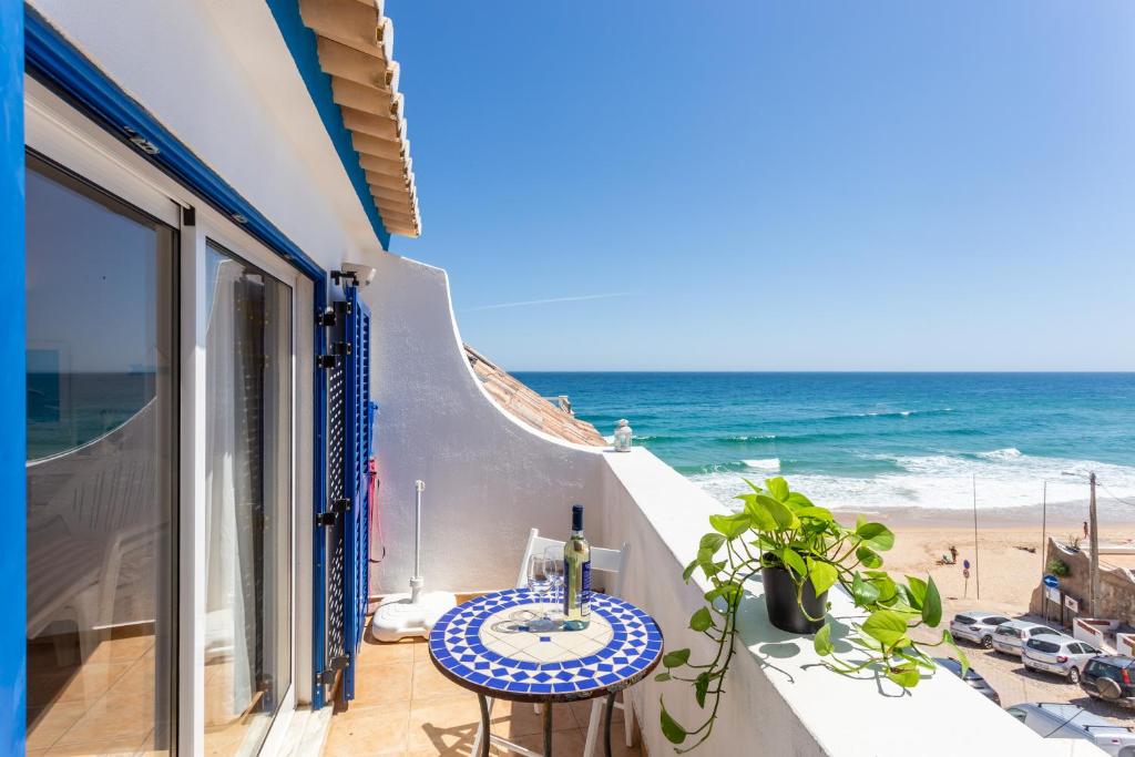 a balcony with a table and a view of the beach at Casa Pedro Burgau in Burgau