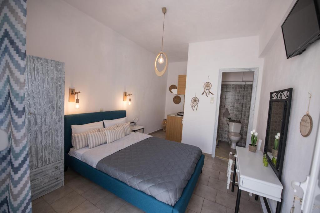 a bedroom with a bed and a table and a television at Vithos in Agnontas