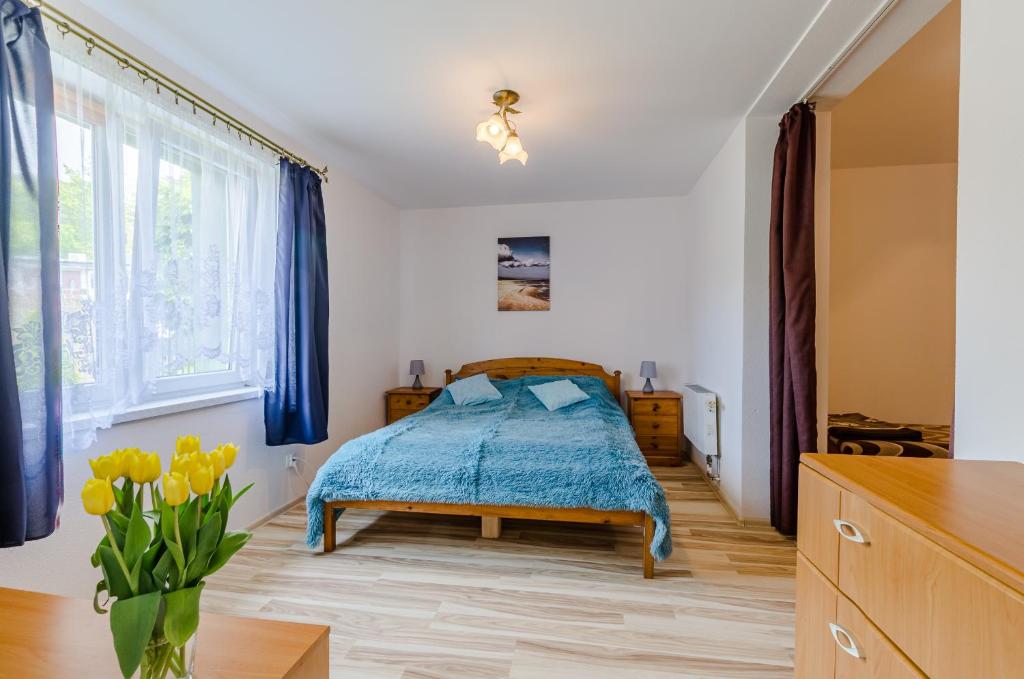a bedroom with a bed and a vase of yellow tulips at Ambelia in Stegna