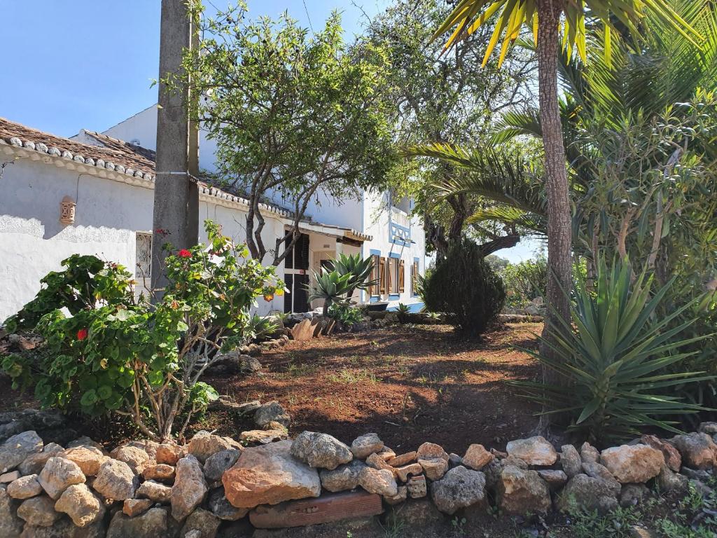 a garden with trees and a stone wall at Hakuna matata in Benagil