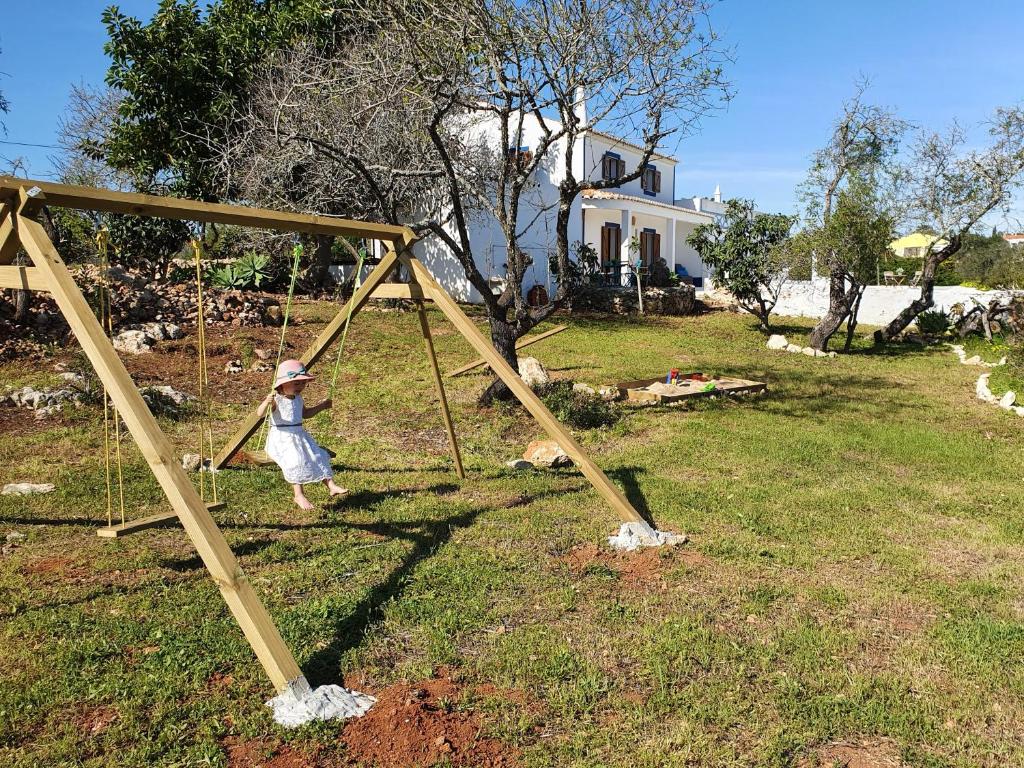 a little girl is playing on a swing at Hakuna matata in Benagil