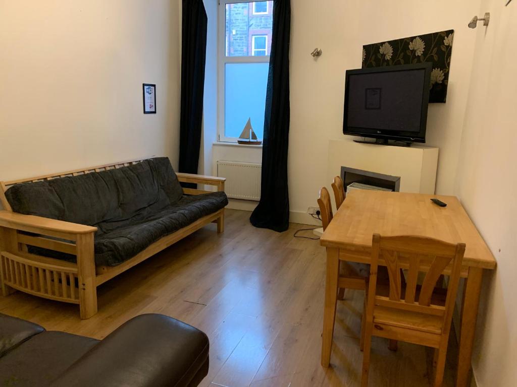 a living room with a couch and a table at Edinburgh Capital Apartments - 49 Elbe Street in Edinburgh