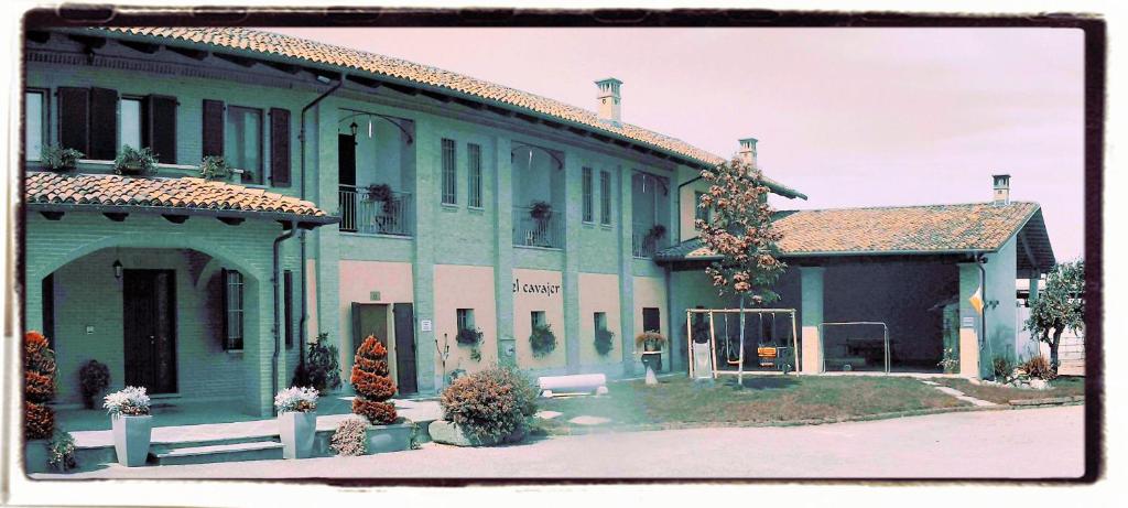 a large green building with a bench in front of it at EL CAVAJER agriturismo-b&b in Revello