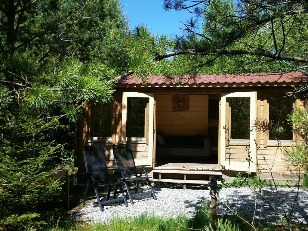 eine Hütte mit zwei Stühlen davor in der Unterkunft Cozy Lodge near Brattforsheden nature reserve in Filipstad