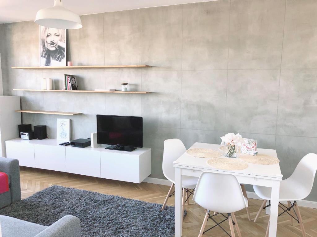 a living room with a white table and white chairs at Seaview Apartament z Balkonem i Widokiem na Morze in Sopot