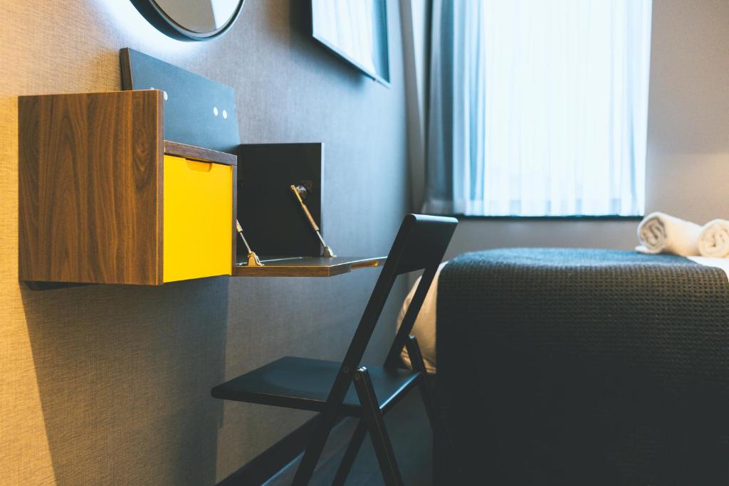 a room with a desk and a chair next to a bed at Point A Hotel London Paddington in London
