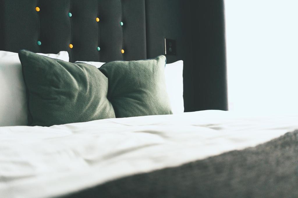 a bed with white sheets and pillows in a bedroom at Point A Hotel London Paddington in London