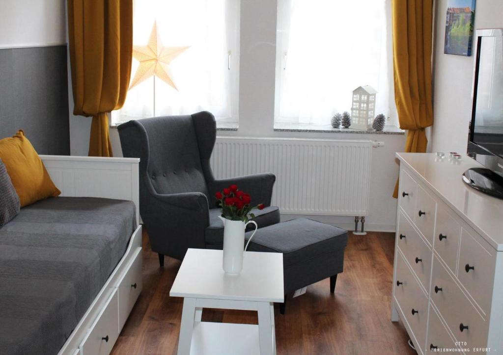 een woonkamer met een bank, een stoel en een tafel bij Ferienwohnung "OTTO" in Erfurt