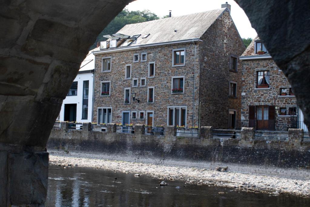 un gran edificio de ladrillo junto a una masa de agua en Typical Ardenne House, en La-Roche-en-Ardenne