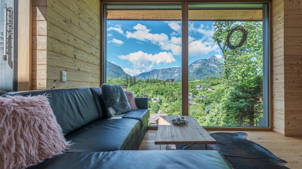 uma sala de estar com um sofá e uma grande janela em Am Sonnenhang em Bad Aussee