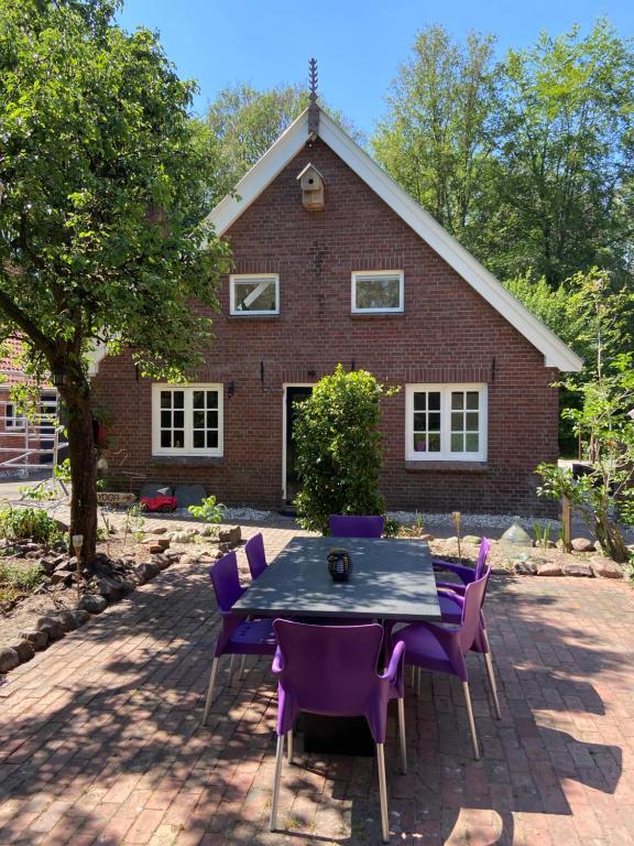 een tafel en stoelen voor een bakstenen huis bij t Melkhuisje - EV lader aanwezig! in Haaksbergen