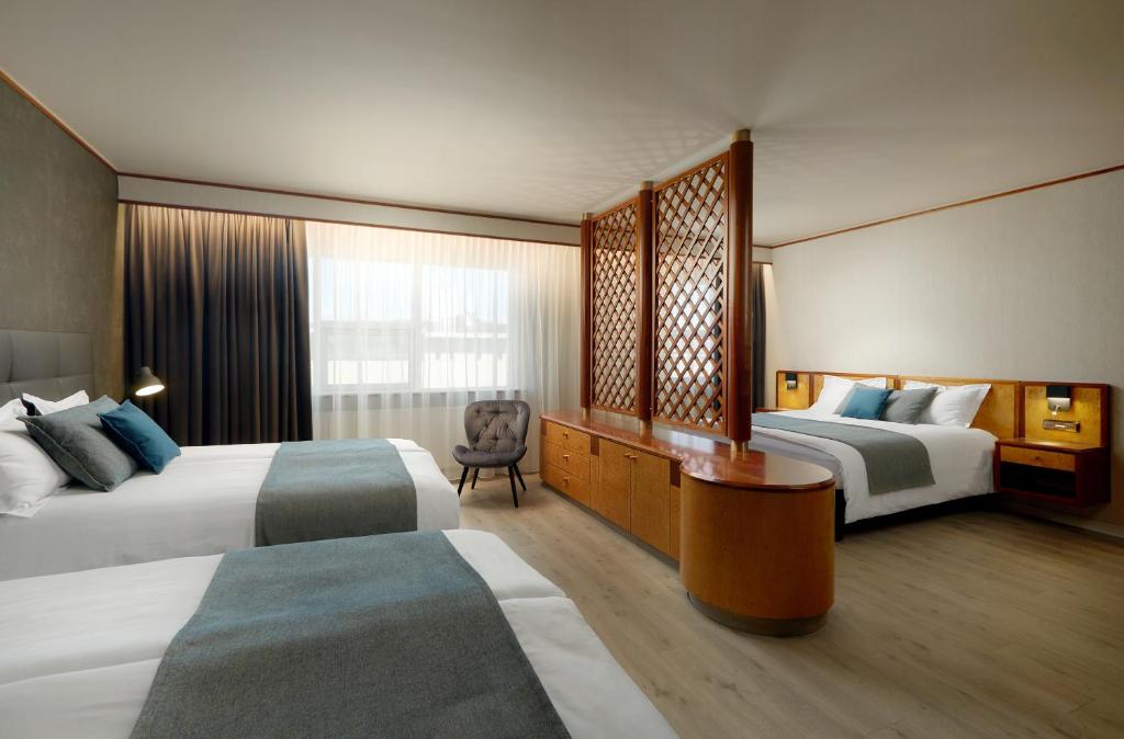 A bed or beds in a room at Hotel Ísland – Spa & Wellness Hotel