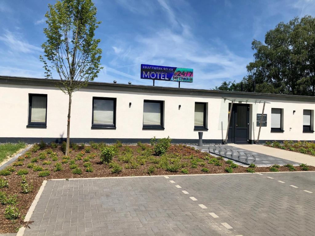 a white building with a sign on top of it at Kraftwerk Relax Motel in Werl