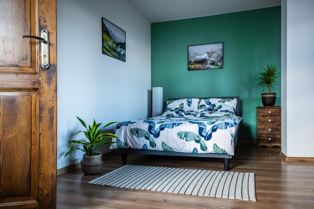 - une chambre avec un lit et un mur vert dans l'établissement Zajazd Izabela, à Żywiec
