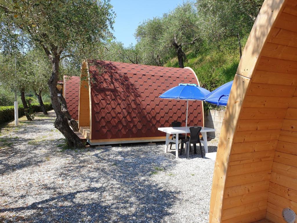 萊里奇的住宿－Campeggio Gianna Golfo dei Poeti，几张桌子和伞,靠近一座建筑