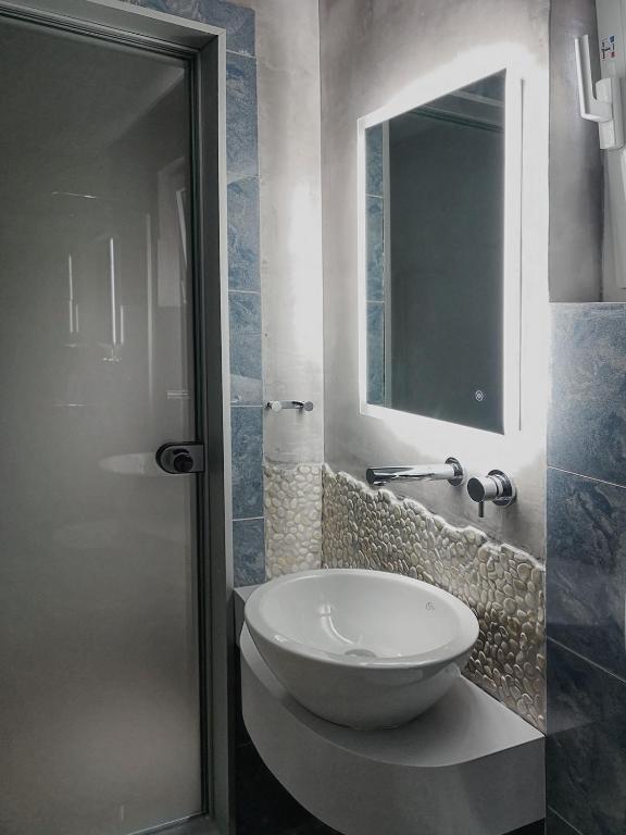 a bathroom with a white sink and a mirror at Haraki Village in Haraki
