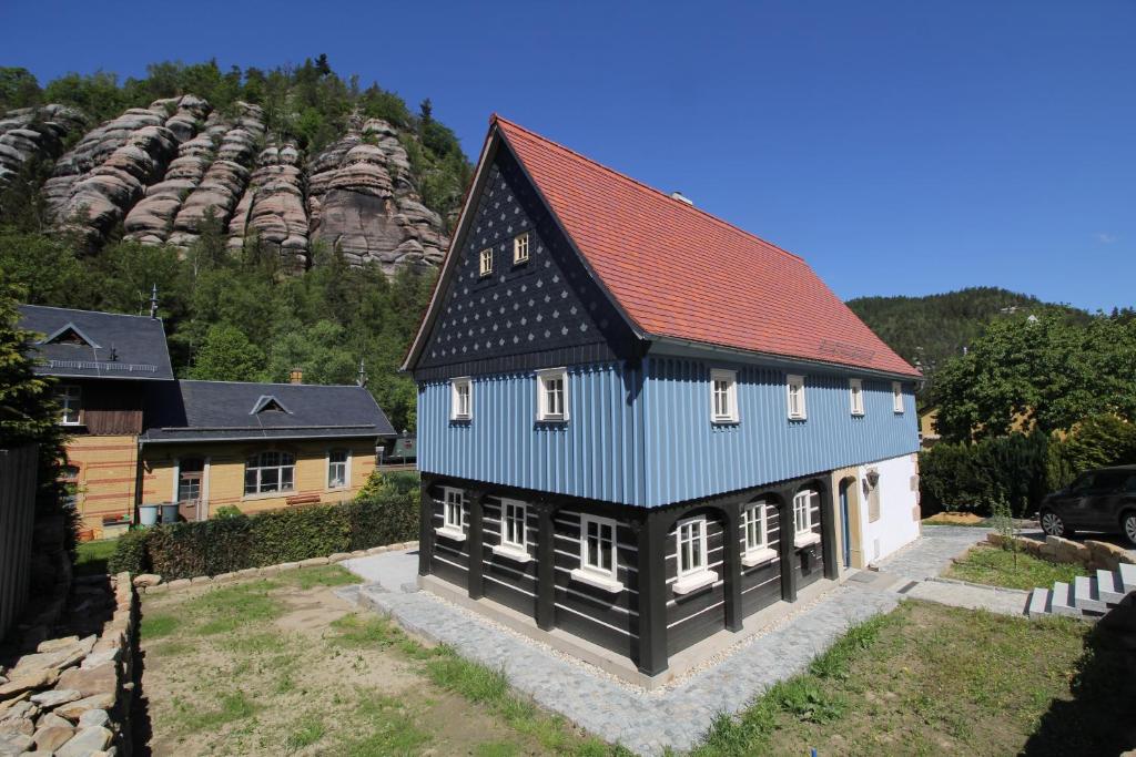 a blue and white house with a red roof at Oberlausitzer Ferienhaus Gebirgshäusl Oybin in Kurort Oybin
