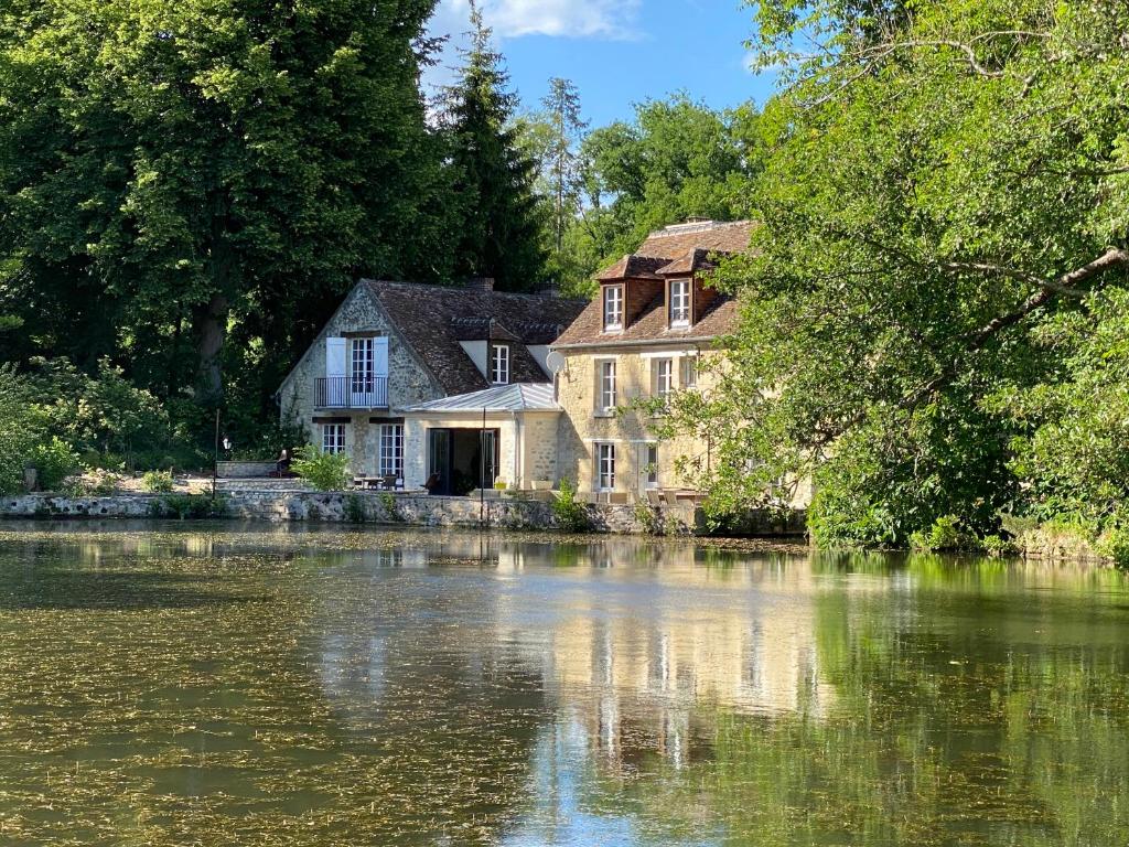une maison assise sur le côté d'un lac dans l'établissement LE MOULIN DE L'ORTILLE, à Compiègne