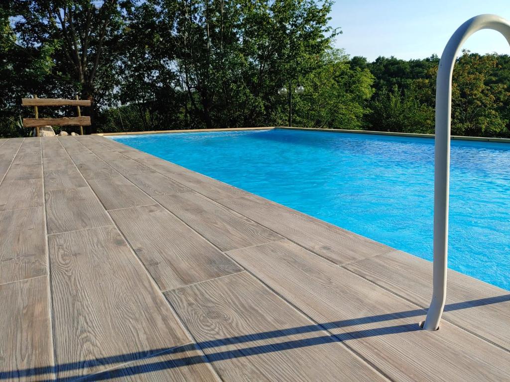 una terraza de madera junto a una piscina en Il carpino bianco bilocale, en Puegnago sul Garda