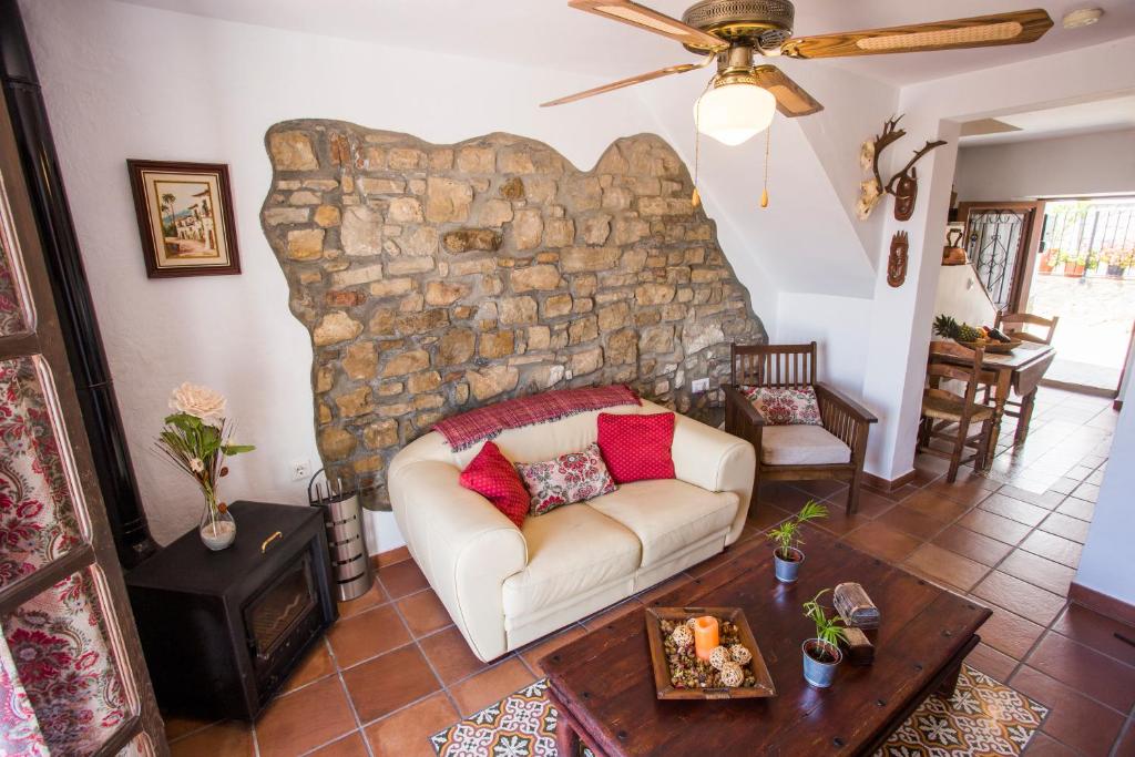 - un salon avec un canapé et un mur en pierre dans l'établissement La Casita De Ana, à Jimena de la Frontera
