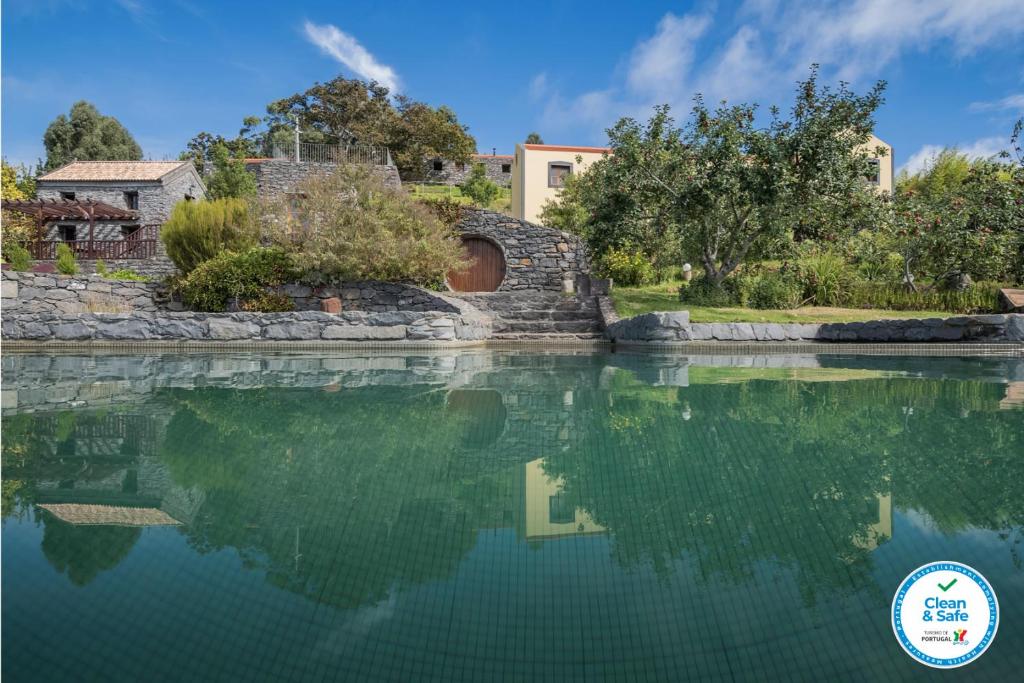 a pool of water in front of a house at Casas da Levada in Ponta do Pargo